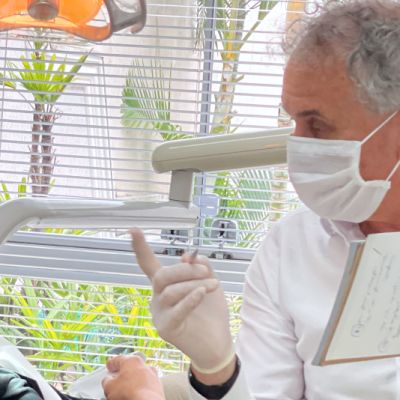 Paciente em consulta com dentista avaliando tomografia.